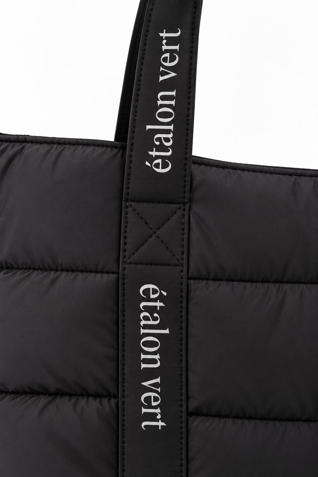 Puffer Bag Black – breiter Träger mit étalon-vert-Schriftzug im Detail