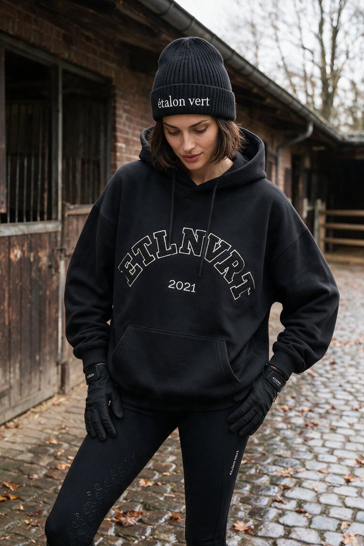 étalon vert – Black ETLNVRT Chenille Hoodie – front three-quarter with hood raised – Elise