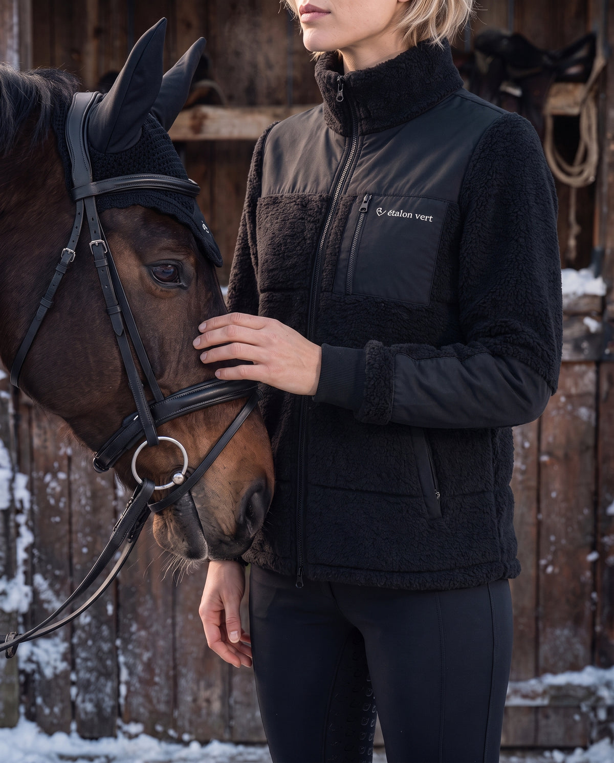 Valegro Teddyjacke Schwarz am Model neben dem Pferd, Brusttasche und Material